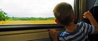 Мальчик смотрит в окно в поезде