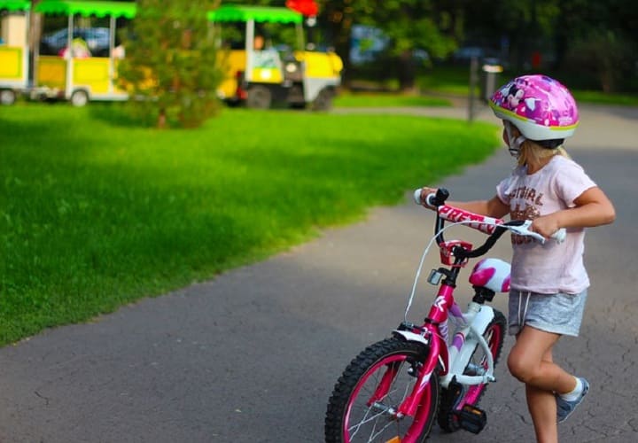 ребенок с велосипедом в парке 